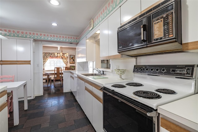 kitchen featuring stone tile flooring, black microwave, white cabinetry, and electric range