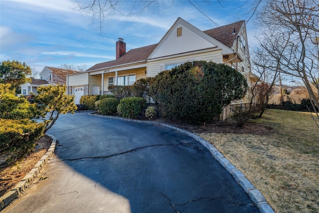 exterior space featuring a chimney and a front lawn