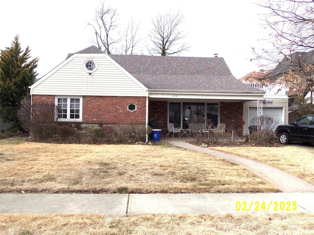 view of front of house with brick siding, roof with shingles, a porch, a garage, and a front lawn