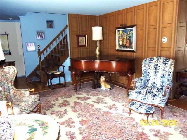 living room featuring baseboards and stairway