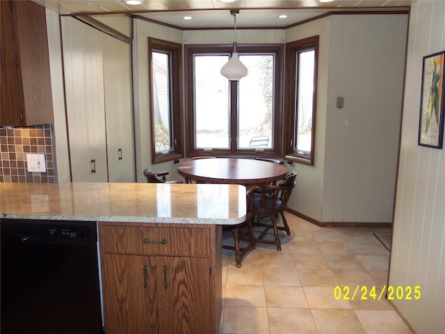 kitchen with baseboards, brown cabinetry, dishwasher, hanging light fixtures, and backsplash