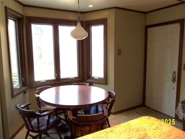 dining area with light tile patterned floors, ornamental molding, and baseboards