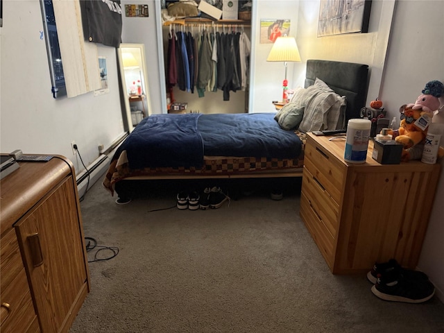 carpeted bedroom with a baseboard heating unit and a closet