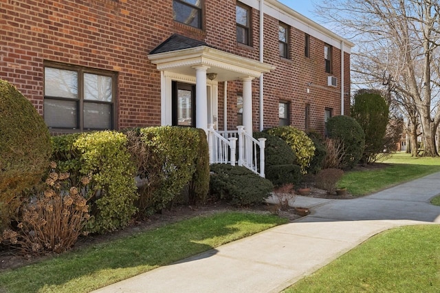 view of exterior entry featuring brick siding