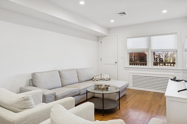 living room with light wood-style flooring, visible vents, and recessed lighting