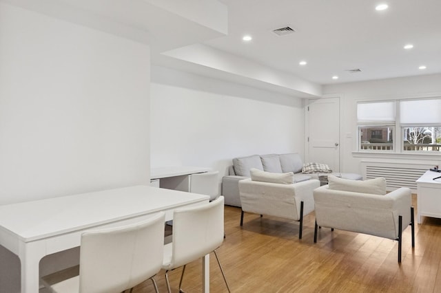 living room featuring light wood-type flooring, visible vents, and recessed lighting