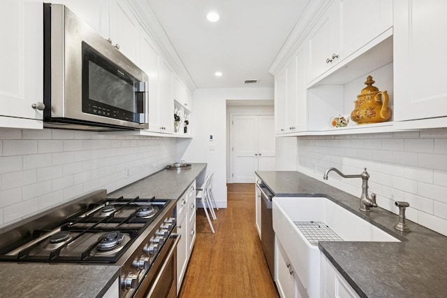 kitchen with dark wood finished floors, open shelves, stainless steel appliances, visible vents, and white cabinetry