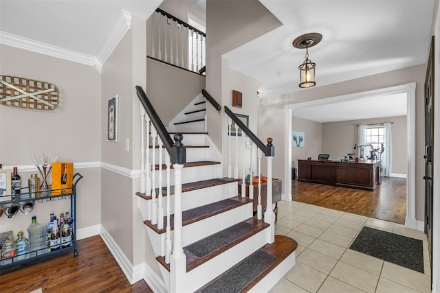 staircase featuring tile patterned floors, baseboards, and crown molding