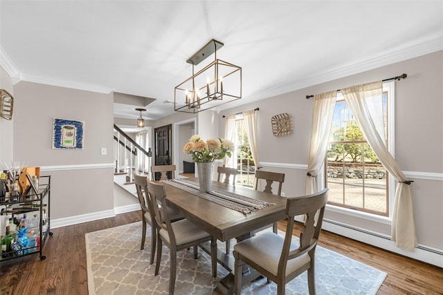 dining space with a baseboard heating unit, stairs, dark wood-style flooring, and a wealth of natural light