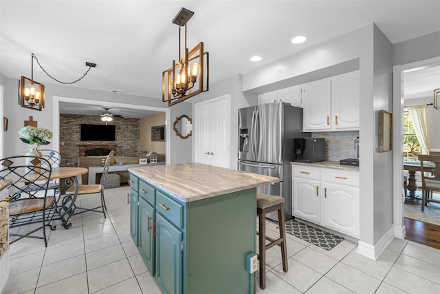 kitchen featuring white cabinetry, stainless steel refrigerator with ice dispenser, backsplash, and a center island