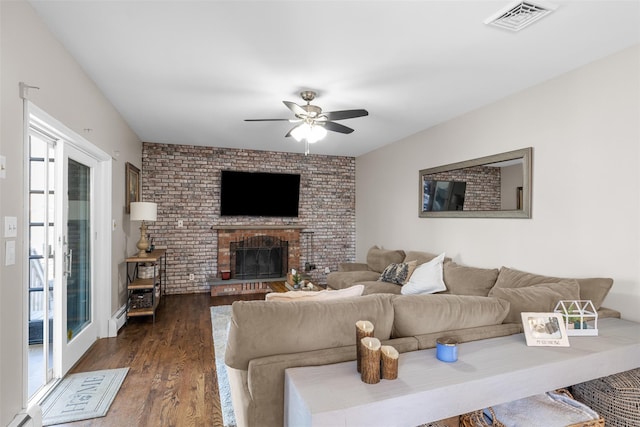 living room featuring visible vents, a ceiling fan, wood finished floors, a fireplace, and a baseboard radiator