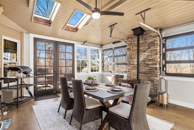 sunroom / solarium with french doors, vaulted ceiling with skylight, wooden ceiling, and a ceiling fan