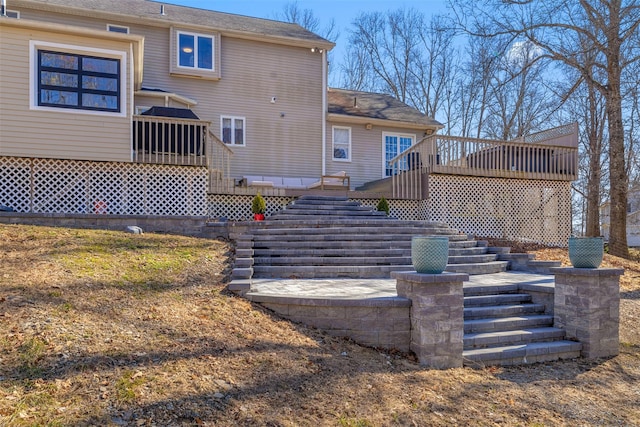 rear view of house featuring stairway and a deck