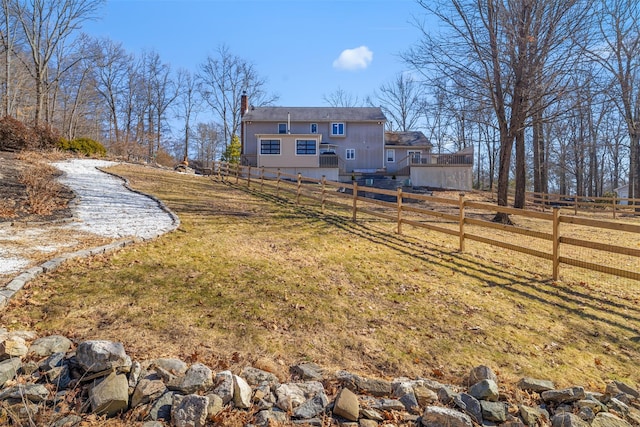 rear view of property with a chimney and fence