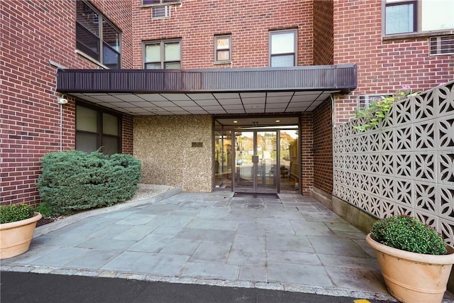 view of exterior entry with french doors and brick siding