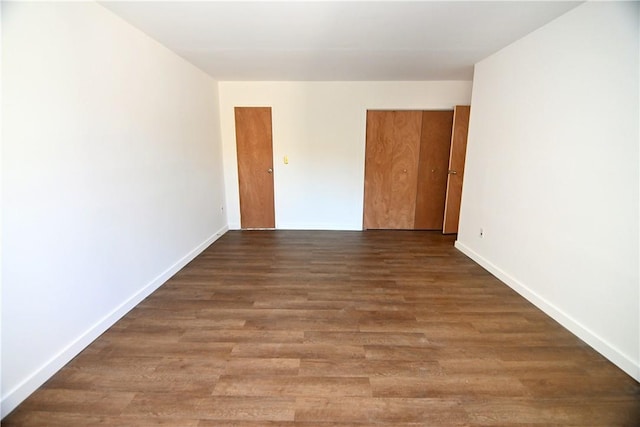 unfurnished room with baseboards and wood finished floors