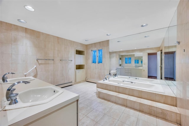 bathroom with double vanity, a baseboard radiator, a sink, and tile walls