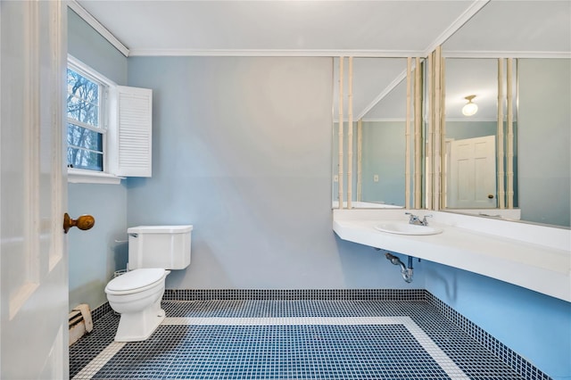 half bathroom featuring toilet, a sink, ornamental molding, baseboard heating, and tile patterned floors