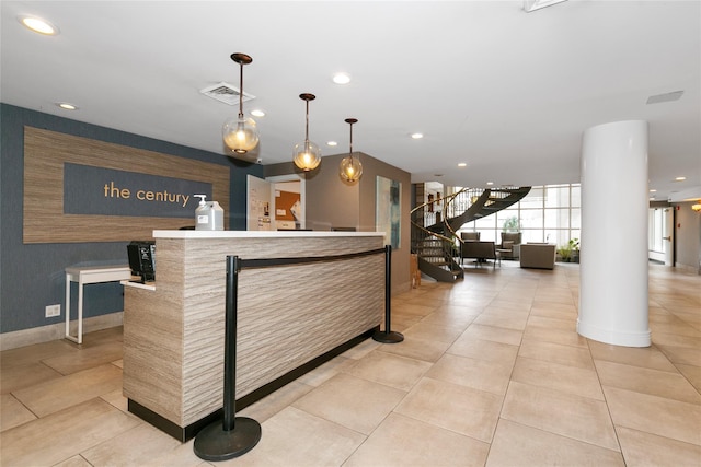 reception area featuring visible vents, ornate columns, and stairs