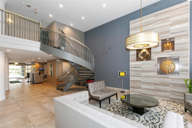 living area featuring baseboards, stairway, tile patterned flooring, a high ceiling, and recessed lighting