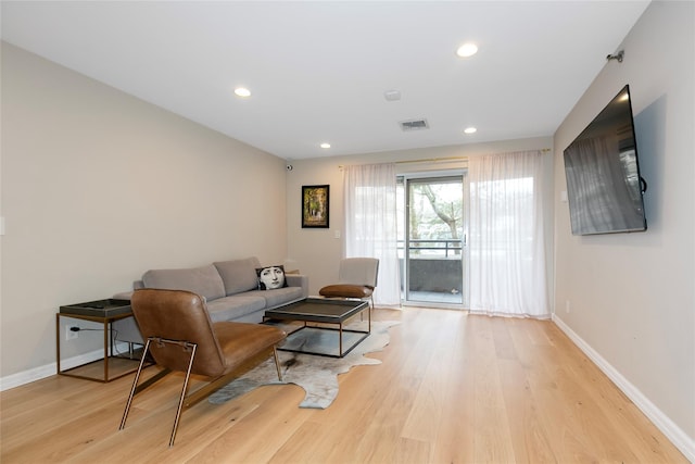 living area with recessed lighting, baseboards, visible vents, and light wood finished floors