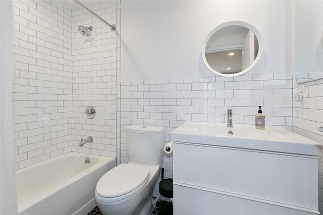 bathroom featuring vanity, bathtub / shower combination, toilet, and tile walls