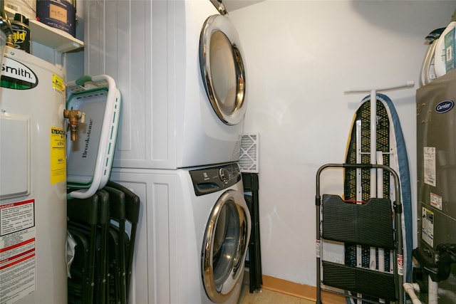 laundry area featuring water heater, laundry area, and stacked washing maching and dryer