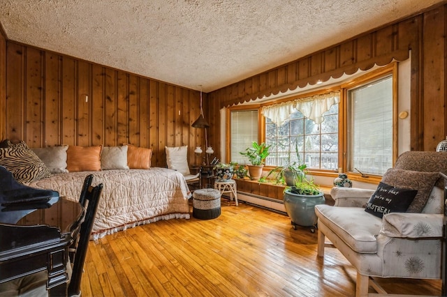 bedroom featuring wood-type flooring, wood walls, and a textured ceiling