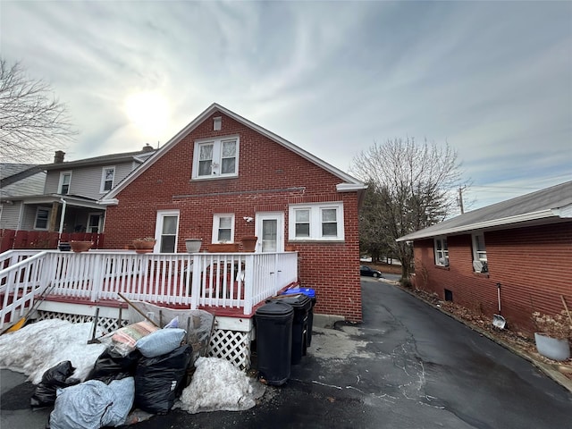 rear view of house with a wooden deck and brick siding