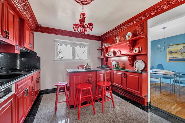 kitchen with a center island, dark countertops, granite finish floor, a chandelier, and baseboards