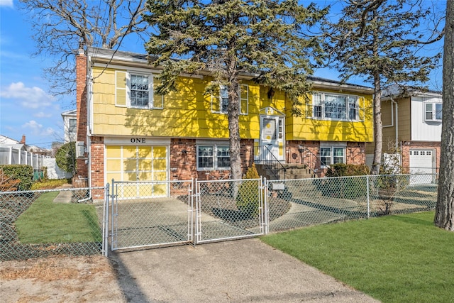 split foyer home featuring driveway, brick siding, a fenced front yard, and a gate