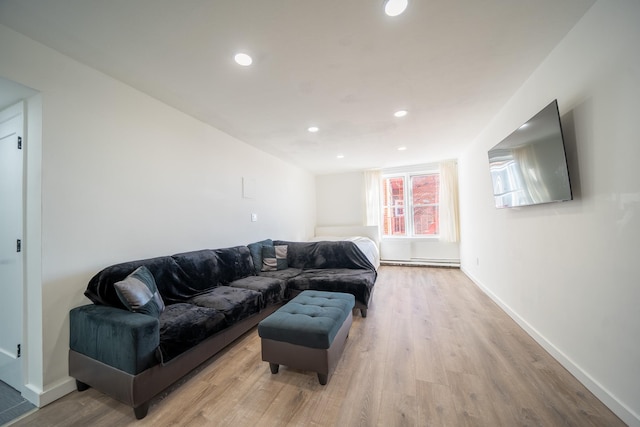 living room featuring light wood-style floors, baseboards, a baseboard heating unit, and recessed lighting