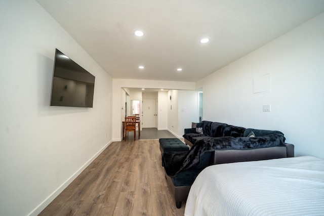 bedroom with recessed lighting, wood finished floors, and baseboards