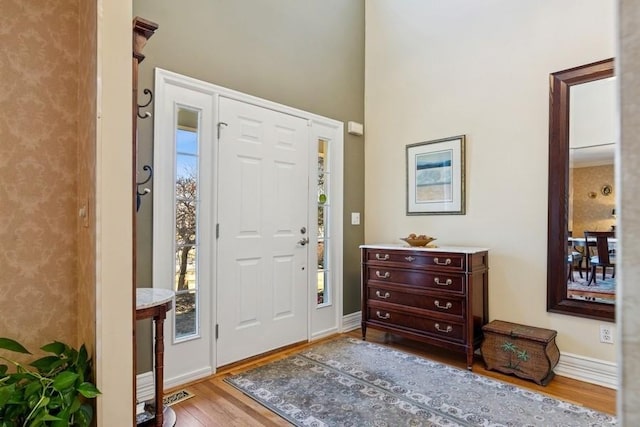 entryway with wood finished floors and baseboards