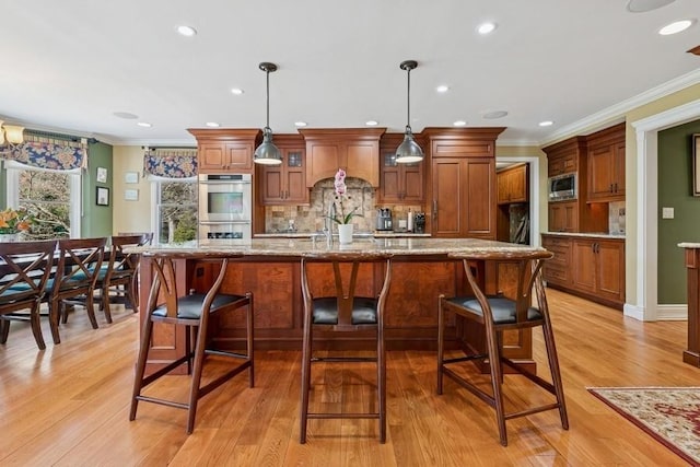 kitchen with premium range hood, stainless steel appliances, tasteful backsplash, and brown cabinetry