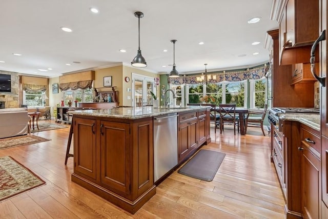 kitchen with light stone counters, a center island with sink, light wood-style flooring, and stainless steel dishwasher