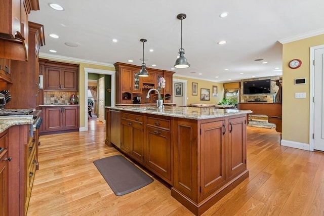 kitchen with ornamental molding, a sink, light wood finished floors, decorative backsplash, and dishwasher