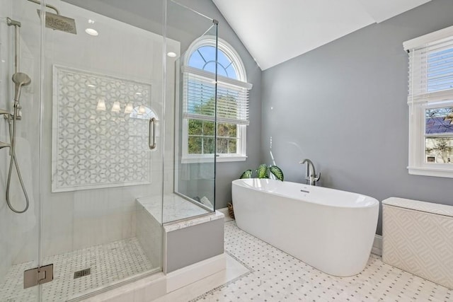 full bathroom featuring lofted ceiling, a soaking tub, and a stall shower