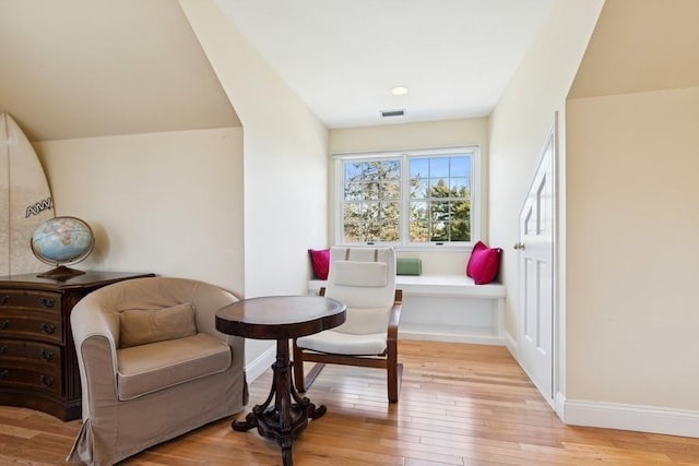 sitting room featuring visible vents, light wood-style flooring, and baseboards