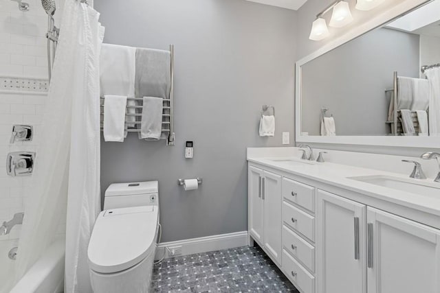 bathroom with double vanity, toilet, baseboards, and a sink