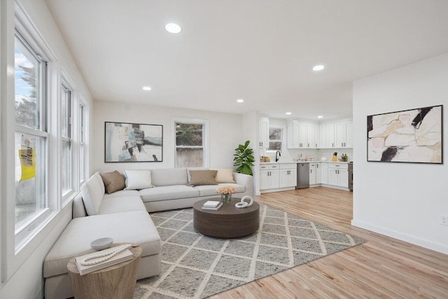 living area featuring light wood-style floors, baseboards, and recessed lighting