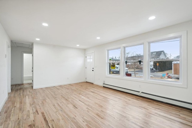 empty room featuring baseboard heating, plenty of natural light, light wood-style flooring, and recessed lighting