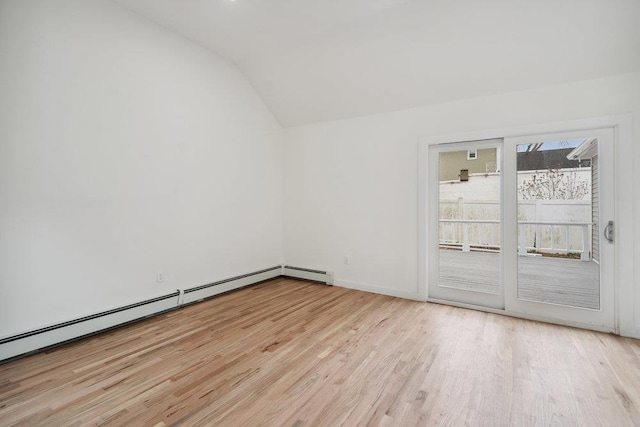 unfurnished room featuring a baseboard heating unit, light wood finished floors, and lofted ceiling