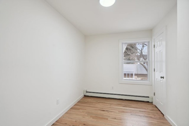 empty room with baseboards, light wood-style flooring, and baseboard heating