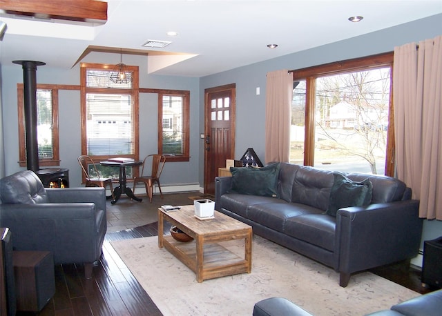 living room featuring recessed lighting, a wood stove, visible vents, and wood finished floors