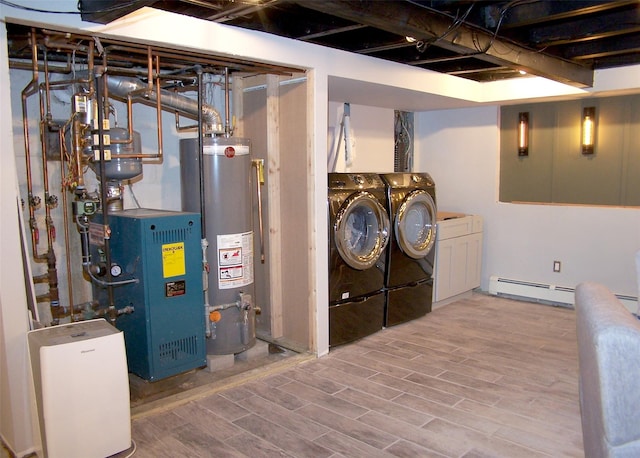 laundry room with a baseboard heating unit, wood finished floors, water heater, washer and clothes dryer, and a heating unit