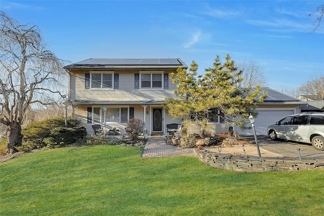 view of front of property with roof mounted solar panels, an attached garage, and a front lawn