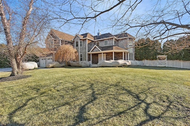 shingle-style home featuring a garage, fence, stone siding, a chimney, and a front yard