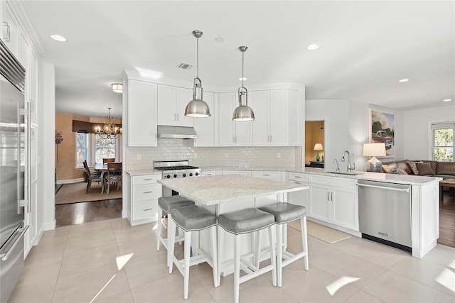 kitchen with tasteful backsplash, visible vents, appliances with stainless steel finishes, under cabinet range hood, and a sink