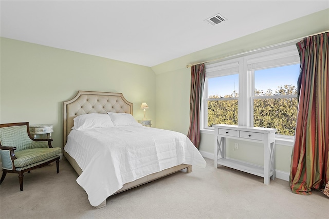 bedroom with lofted ceiling, visible vents, light carpet, and baseboards